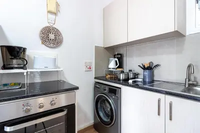 a kitchen with a washing machine and a sink at Lazy River 1-Bedroom Apartment in Larnaka