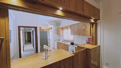 a kitchen with wooden cabinets and a wooden counter top at STAY Aurum Apartment in Nicosia