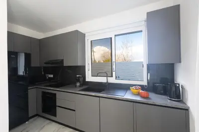 a kitchen with black and white cabinets and a window at Mandali Villa 20 - Fully Renovated Villa in Paralimni
