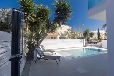 a swimming pool with a chair next to a house at Mandali Villa 20 - Fully Renovated Villa in Paralimni