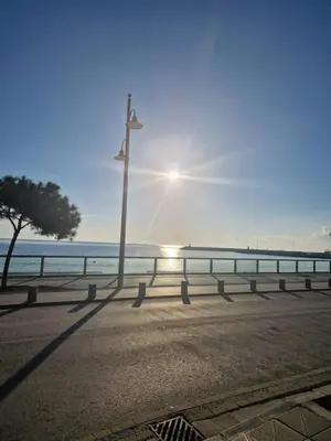 a street light on the beach with the sun in the background at Seaview City Retreat in Larnaka
