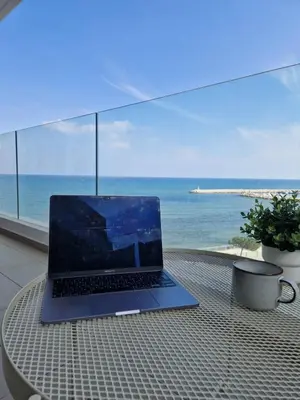 a laptop sitting on a table with a view of the ocean at Seaview City Retreat in Larnaka