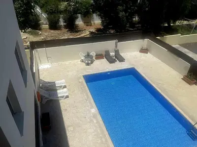 an overhead view of a swimming pool with two lawn chairs at Sofia`s place in Voroklini