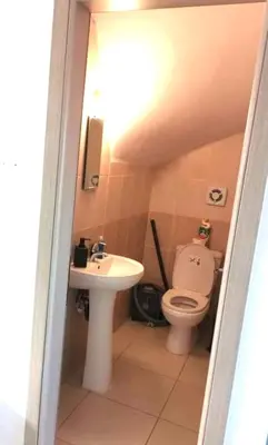 a small bathroom with a toilet and a sink at Ionian Breeze Family House Walk to Beach And Dining in Paralimni