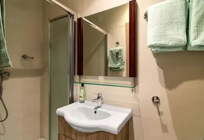 a bathroom with a sink and a mirror at Beach Walk - Central, Cool, Cute, Convenient in Limassol