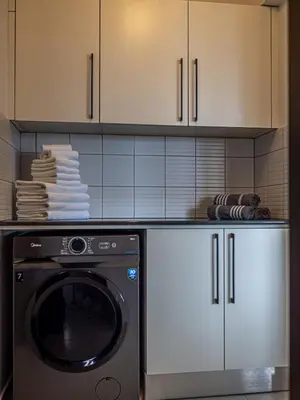 a kitchen with a dishwasher and white cabinets at Cozy sea view Apartment in Mazotos