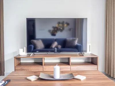 a living room with a blue couch in front of a tv at Cozy sea view Apartment in Mazotos
