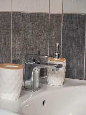 a bathroom sink with a faucet and a roll of toilet paper at Cozy sea view Apartment in Mazotos