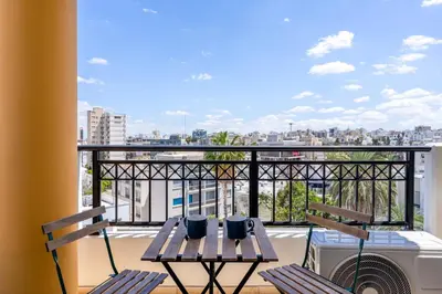 a balcony with two chairs and a table with a view at Stylish Central Apartment • City Views • Prime Location • Parking in Nicosia