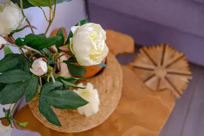 a vase with white roses on a table at Endless Summer Beach House in Pervolia