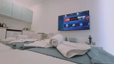 a room with four towels and a tv on the wall at STAY Napa Oasis Studio in Ayia Napa