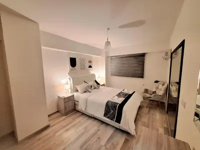a white bedroom with a bed and a couch at Abstract by the Sea in Larnaka