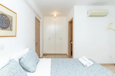 a white bedroom with a bed with two pillows at Niki Seaview Villa DPS27 in Protaras