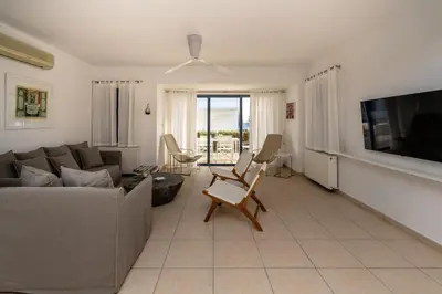 a living room with a couch and a tv at Niki Seaview Villa DPS27 in Protaras