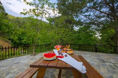 a wooden picnic table with a slice of watermelon on it at VILLa PERSEPHONE in Platres