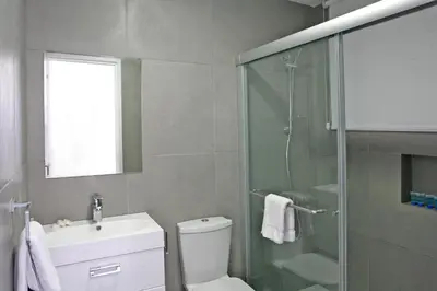 a bathroom with a shower and a toilet and a sink at Corina Suites & Apartments in Limassol