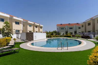 a swimming pool in the middle of a yard with buildings at Modern Townhouse with pool ten minutes Limassol Center in Limassol