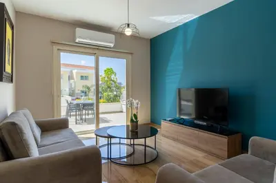 a living room with a couch and a tv at Modern Townhouse with pool ten minutes Limassol Center in Limassol
