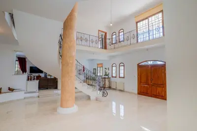 a large living room with stairs and a column at Aέναη in Pyrga