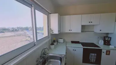 a kitchen with a sink and a large window at STAY Sea and Salt Lake Panoramic View Apt in Larnaka