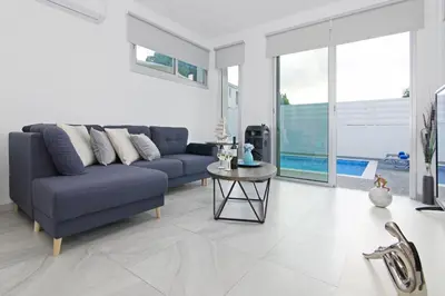 a living room with a blue couch and a table at Thea Athena Villa - Walking to the Beach in Paralimni