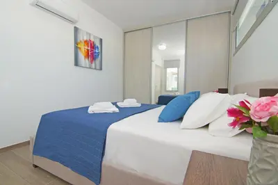 a bedroom with a large bed with blue and white pillows at Thea Athena Villa - Walking to the Beach in Paralimni