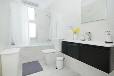 a white bathroom with a toilet and a sink at Thea Athena Villa - Walking to the Beach in Paralimni
