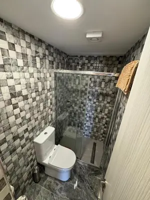 a bathroom with a toilet and a glass shower at Marisa Napa Suites Ayia Napa in Ayia Napa