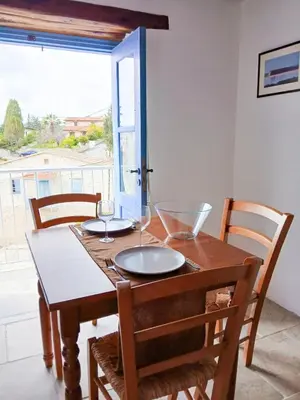 a wooden table with two wine glasses on it at Cozy Courtyard Apartment in Skarinou