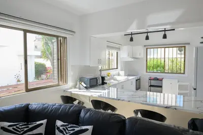 a living room with a couch and a kitchen at Cavo Greco Oasis in Protaras