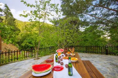 a table with food and drinks on a wooden bench at Amazing Villa in Pano Platres Cyprus in Kato Platres