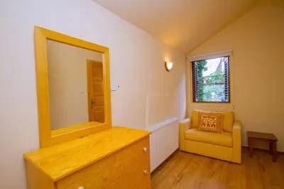 a mirror on a dresser in a room with a chair at Amazing Villa in Pano Platres Cyprus in Kato Platres