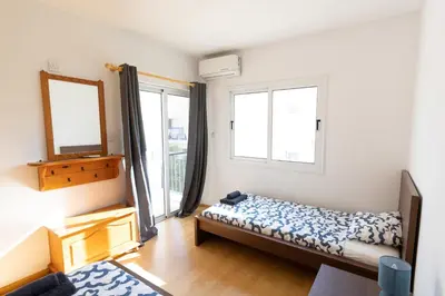 a bedroom with a bed and a mirror and windows at Downtown apartment - Ayia Napa in Ayia Napa