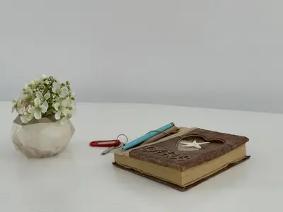 a book sitting next to a vase of flowers at Modern Seaside Retreat Near Nissi Beach in Ayia Napa
