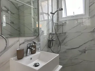 a white bathroom with a sink and a shower at Modern Seaside Retreat Near Nissi Beach in Ayia Napa
