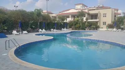 a swimming pool in front of a building at Pyla Gardens A104 in Pyla