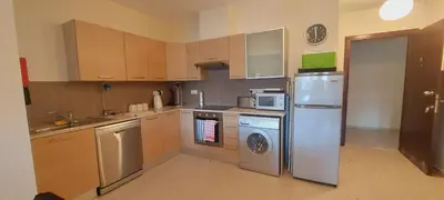 a kitchen with a refrigerator and a dishwasher at Pyla Gardens A104 in Pyla