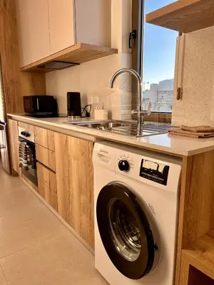 a washing machine in a kitchen with a sink at 9 Muses Holiday apartments in Larnaka