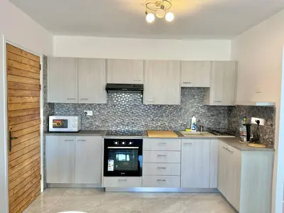 a kitchen with white cabinets and a stove top oven at Stay With Oleg 102A in Paralimni