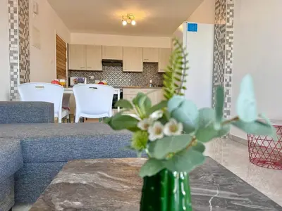 a green vase with flowers sitting on a table at Stay With Oleg 102A in Paralimni