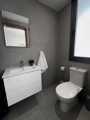 a bathroom with a white toilet and a sink at Rachel 401 in Larnaka