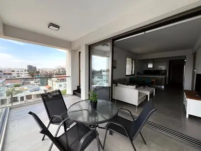 a living room with a glass table and chairs at Rachel 401 in Larnaka