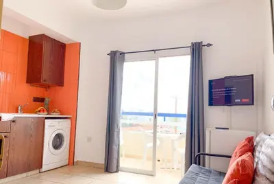 a kitchen with a washing machine and a window at HeartCore Holiday Apartments in Ayia Napa
