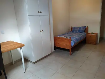 a small bedroom with a bed and a cabinet at The Tower Penthouse in Strovolos