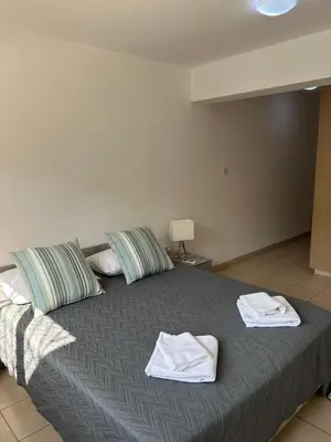 a bedroom with a bed with towels on it at Beautiful 2 Bed Ground Floor Apartment With Pool in Paralimni