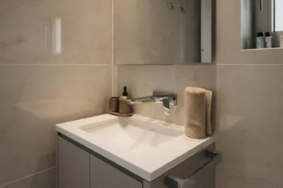 a bathroom with a white sink and a mirror at New Luxury 2BR Seaview Apt, Sun City, Pool and Beach in Ayia Napa