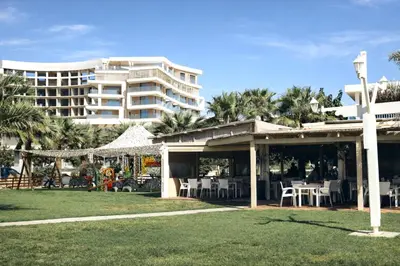 a cross in front of a building with tables and chairs at New Luxury 2BR Seaview Apt, Sun City, Pool and Beach in Ayia Napa