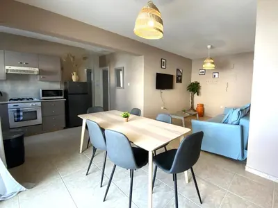 a kitchen and dining room with a table and chairs at 2 Beachside Apts, 5min Walk to Shore with Internet in Larnaka