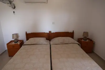 a bedroom with two beds and two lamps on night stands at Monolithos Cottage in Pachna