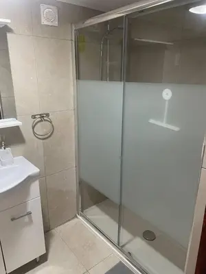 a shower with a glass door in a bathroom at Monolithos Cottage in Pachna